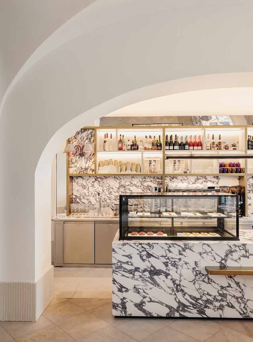 Die Patisserie Amalia heute: Theke mit Glasvitrine und Marmorverkleidung unter einem weißen Gewölbebogen, dahinter beleuchtete Regale
