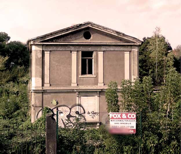 Die Villa vor der Sanierung: Ruine mit Graffiti hinter Gestrüpp